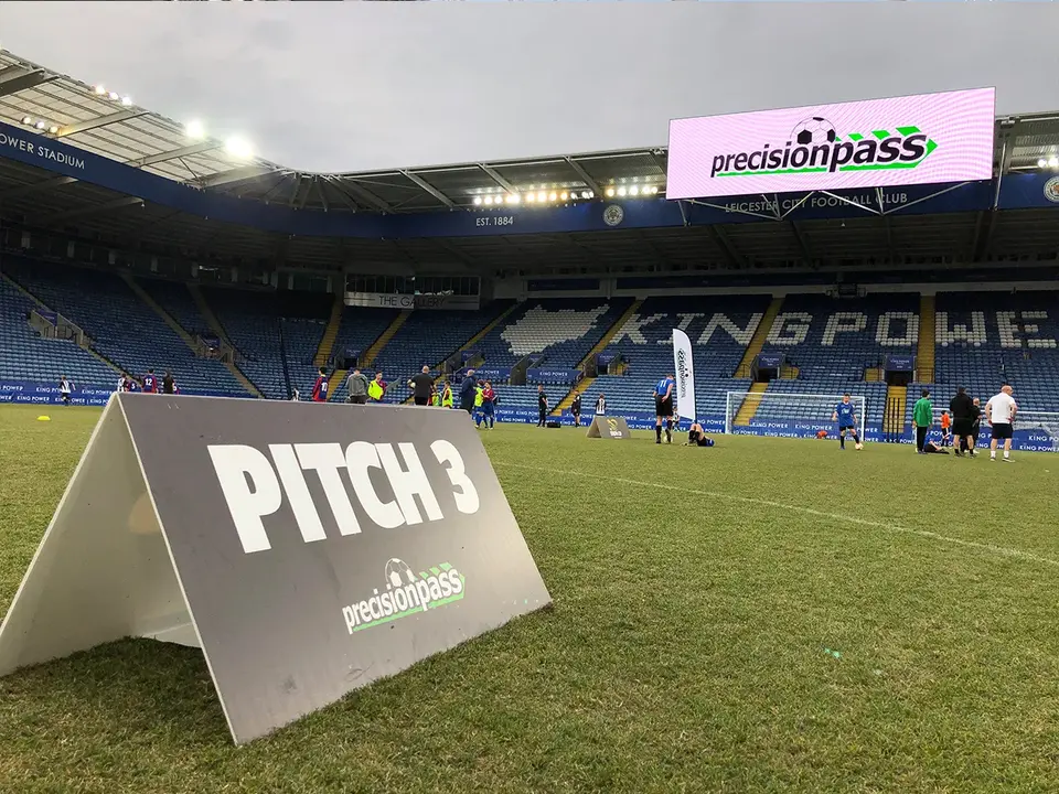 Youth footballers playing on a professional stadium pitch