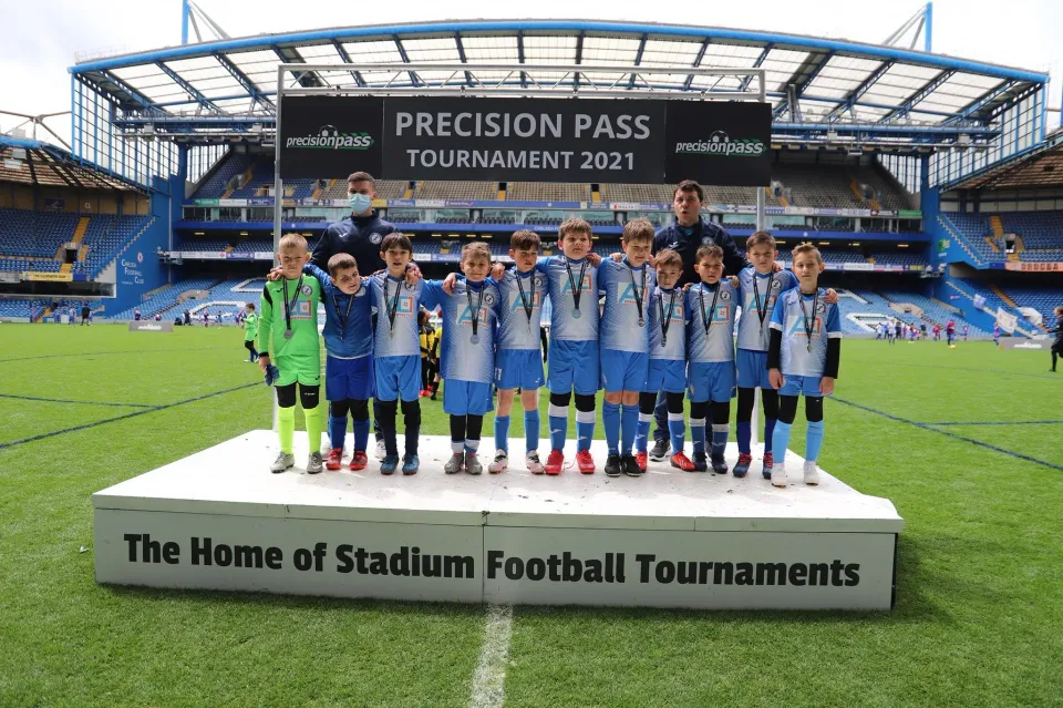 Young players celebrating together after a stadium tournament.